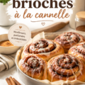 Brioches à la cannelle moelleuses sur une assiette, entourées de cannelle en poudre et de sucre juste saupoudré.